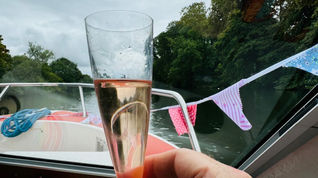 Raising a glass in celebration while on a boat on the Thames