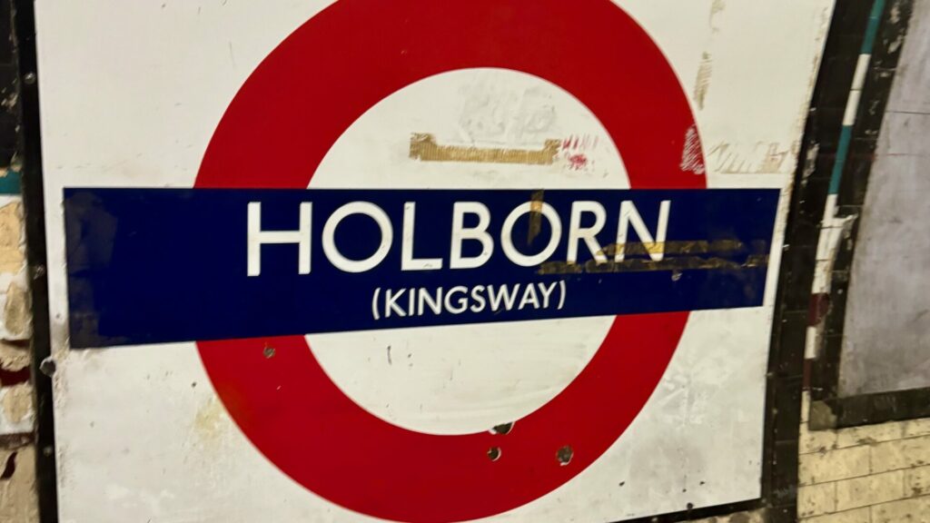 A London Underground roundel at Holborn, the last one featuring Kingsway in brackets on the sign