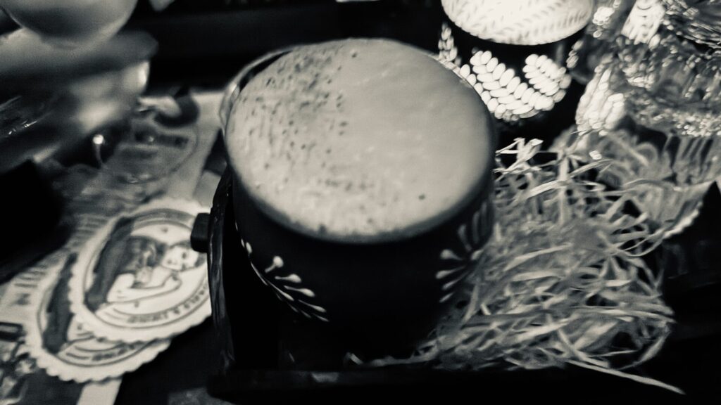 A back and white photograph of a cocktail on a table.